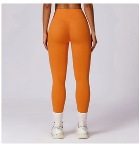Close-up of high-waist orange yoga leggings featuring a V-shaped back lifting seam design