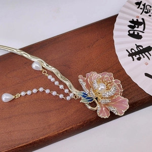 Detailed close-up of pink peony hair pin with pearl tassels on a vintage wooden surface