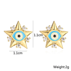 Detail shot of 18K gold star stud earrings with blue evil eye design and tiny crystals