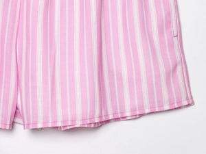 Detailed close-up of pink and white vertical striped woven fabric on shorts hemline