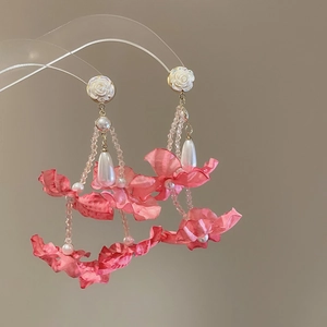 Detail of pink fabric flower earrings with long tassels and elegant pearl accents