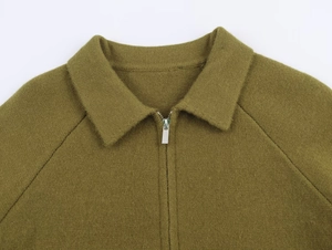 Dettaglio della maglia in maglia verde oliva con colletto dritto e cerniera in metallo argento