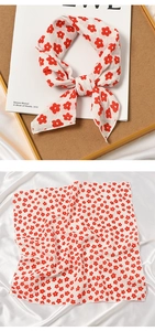 Detail of floral cotton linen square scarf tied in a bow and laid flat on silk fabric