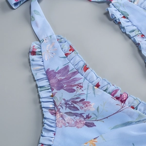 Detailansicht eines blauen Blumen-Chiffonkleids mit Volantlagen und gestuftem Saumdesign