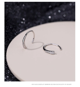 Macro shot of silver stud earrings with sparkling cubic zirconia on a minimalist stage