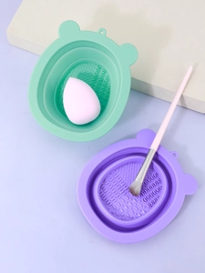Detail of collapsible silicone makeup brush cleaning bowl in mint green and lilac colors