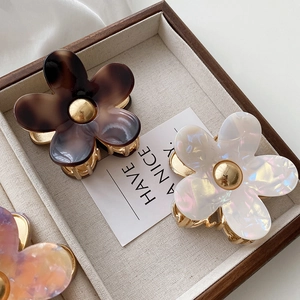 Floral acetate hair claw clip with shell texture and gold metal accents in a gift box