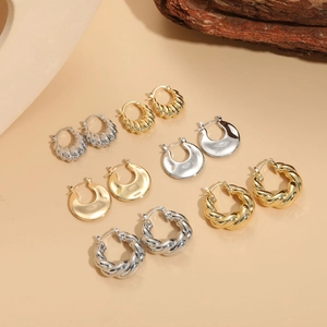 Set of six pairs of geometric hoop earrings in gold and silver finishes on display