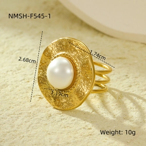 Macro view of 18K gold textured round ring with pearl inlay and triple-line hollow band