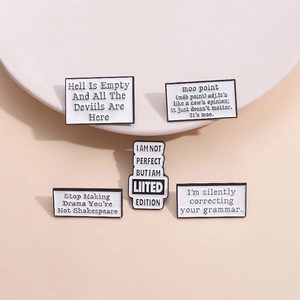 Set of 5 minimalist white enamel brooches with black English quotes on a beige backdrop