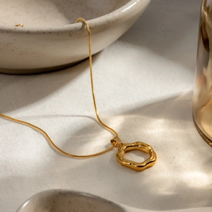 Detail of 18k gold plated stainless steel irregular hammered pendant on snake chain