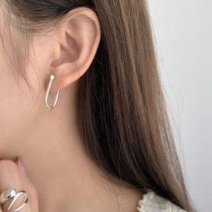 Close-up of minimalist S925 sterling silver U-shaped hoop earrings worn by a model