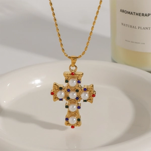 Dettaglio collana a croce barocca dorata con perle e pietre preziose colorate