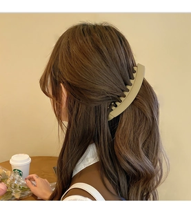 Detail view of khaki matte banana hair clip securing a high ponytail in Korean style