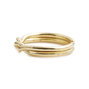 Minimalist French style adjustable golden twist knot ring for women on white background