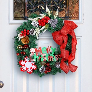 Green pine needle Christmas wreath with red bow and Merry Christmas sign on white door