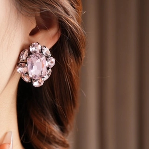 Gros plan de boucles d'oreilles flocon vintage avec cristaux roses sur l'oreille