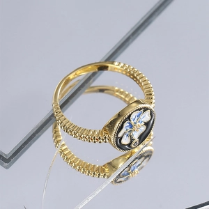 Vintage gold ring with black enamel flower inlay and zircon, shown with reflection