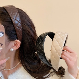 Detail of wide quilted faux leather headbands in brown black and beige colors