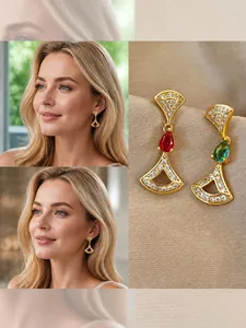 Detail of 14K gold plated teardrop earrings with red and teal gems in fan-shaped design
