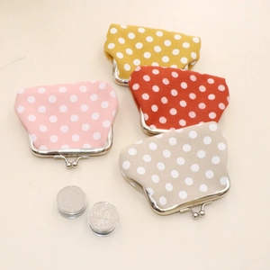 Detail of vintage polka dot canvas coin purses with metal clasps and loose coins