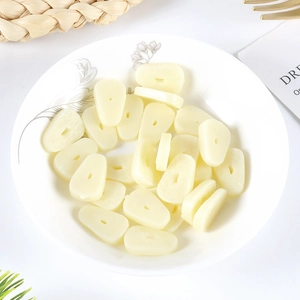 Realistic PVC garlic slices miniatures for DIY craft accessories in a white ceramic plate