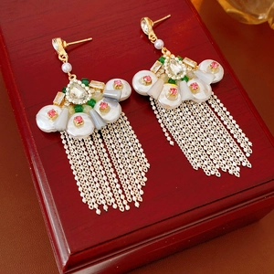 Detailed close-up of vintage fan-shaped earrings with pearls and colorful tassels