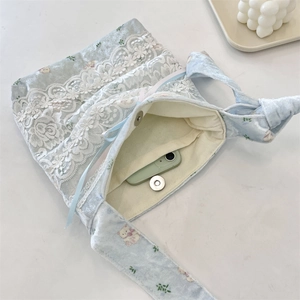 Detailed view of light blue shoulder bag with lace, cute bear print and magnetic closure