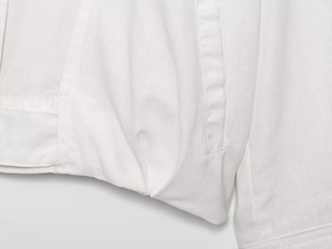Close-up of white woven fabric texture showing fine stitching and natural linen cotton blend