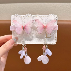 Close-up of pink butterfly hair clips with beaded tassels and silver metallic accents