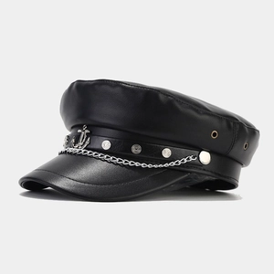 Dettaglio laterale di cappello militare in pelle nera con catena argentata ed emblema