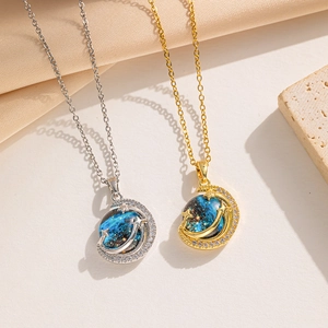 Macro detail of crescent moon and blue galaxy sphere pendants with pavé zircons