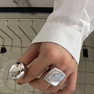Detail of square convex and irregular pebble silver rings with polished mirror finish