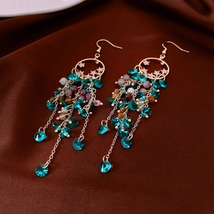 Detailed shot of bohemian tassel earrings with colorful crystal beads on brown silk