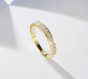Close-up of golden S925 silver ring with channel-set sparkling cubic zirconia diamonds