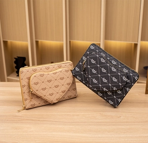 Detail der herzförmigen Vordertasche und Monogramm-Druck auf beigen und schwarzen Taschen