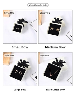 Detailed view of white jewelry gift boxes with black bows and various sizes shown in a grid