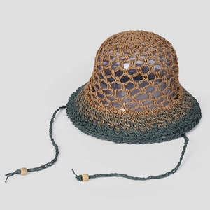 Detailed knit texture of crochet straw hat with green brim and wooden bead strap