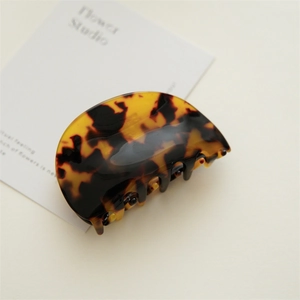 Close-up of a tortoiseshell acetate hair claw clip with polished finish and strong grip