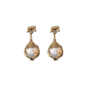 Vintage gold earrings with large pearls and floral metal frames on white background