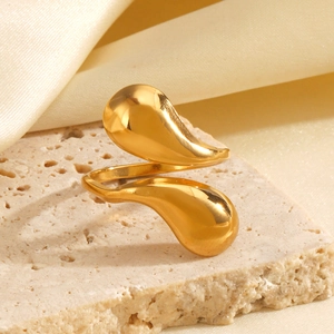 Polished 18K gold-plated teardrop ring on natural stone and silk fabric background