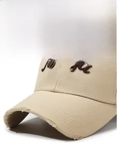 Detail of distressed brim and 3D 1990 embroidery on vintage beige baseball cap