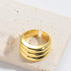 Detail of adjustable gold knot ring with triple-layered design on natural stone base