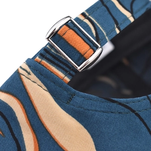 Detail of adjustable metal buckle on teal tie-dye baseball cap with abstract patterns