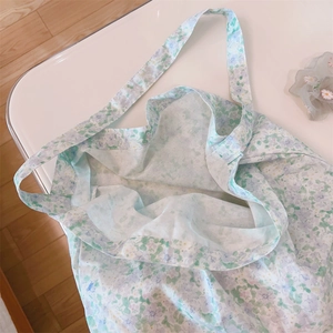 Primer plano de un bolso de algodón con flores que muestra la suave textura de la tela.
