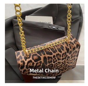 Close-up of leopard print crossbody bag featuring gold chain strap and metal hardware