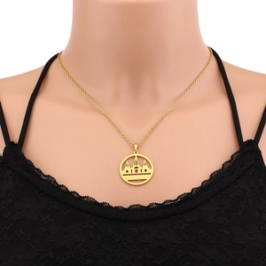 Detailed close-up of a gold-plated Lalish temple pendant necklace on a model