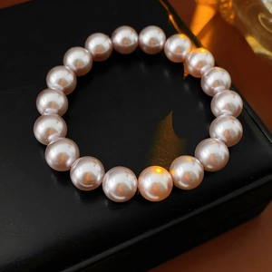 Macro detail of elegant pink pearl bracelet with high luster on a black jewelry box