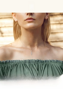 Close-up of elegant S925 sterling silver three-stone diamond pendant on a model's neck