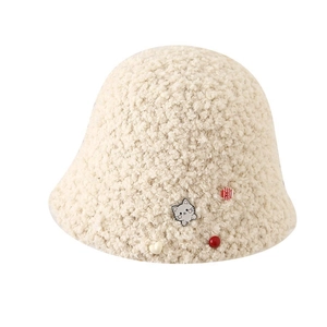 Détail du chapeau bob en peluche beige avec broche chat mignon et décor de cœur